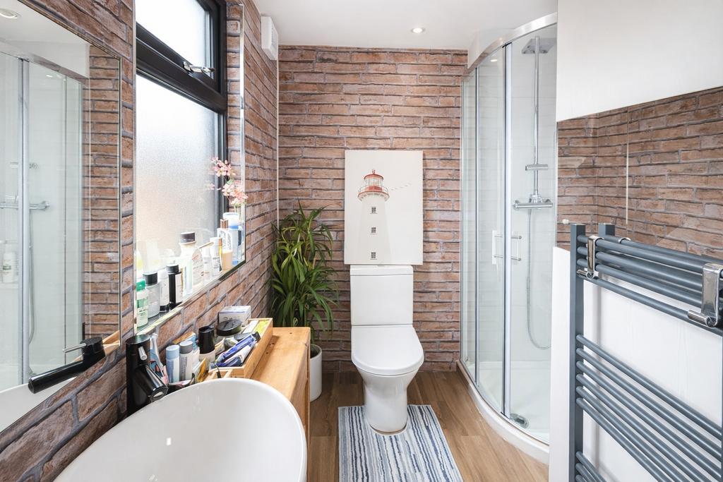 Bright modern bathroom with a curved glass show...