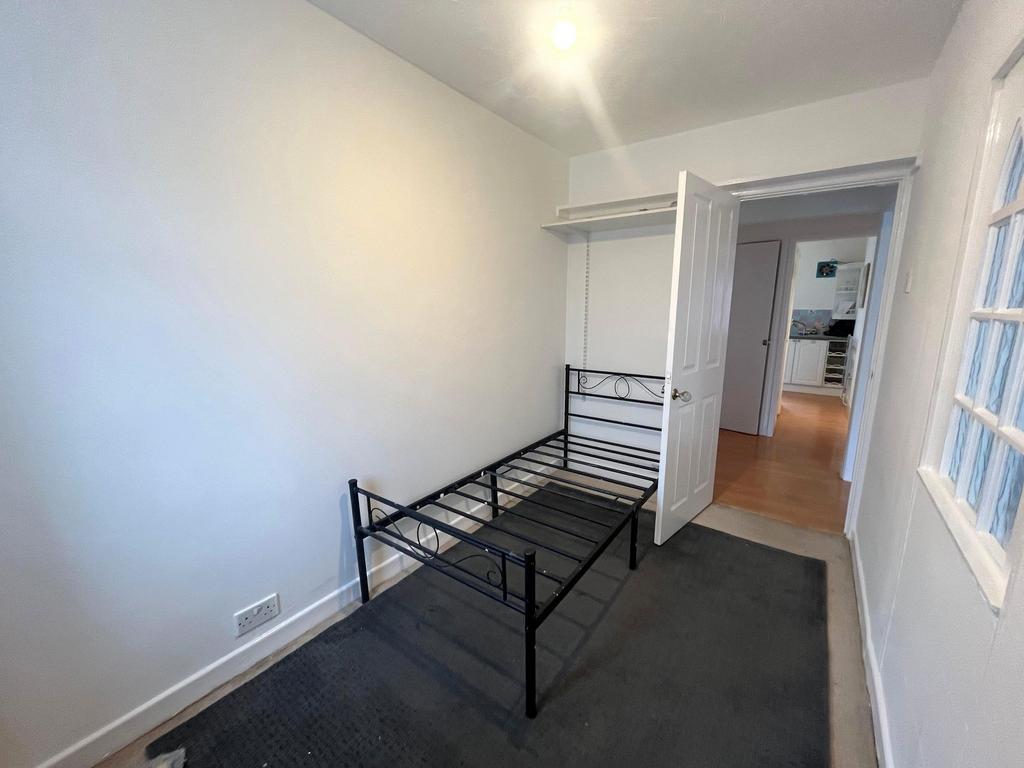 Small bedroom with fresh white walls, a black m...
