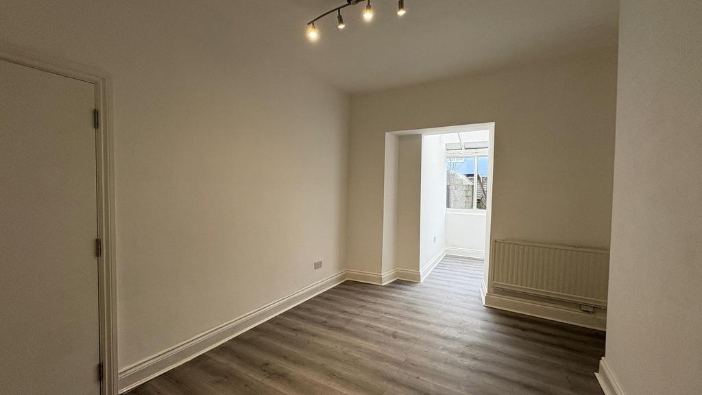 Bright, freshly painted living area with contem...