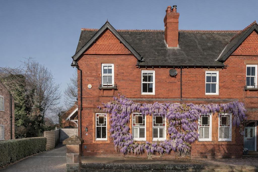 Red brick house with wisteria blooms.png