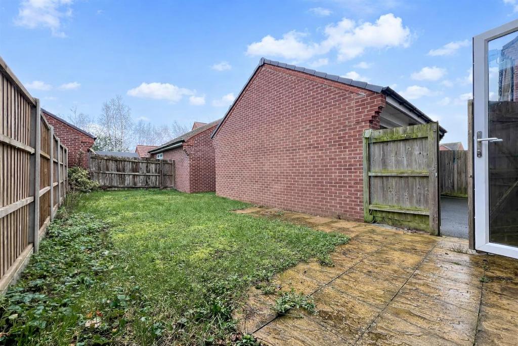 Sunny suburban backyard with open gate (1).png