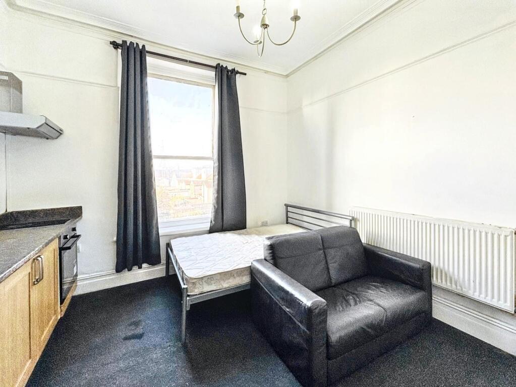 Bright, simply furnished bedroom with a double ...