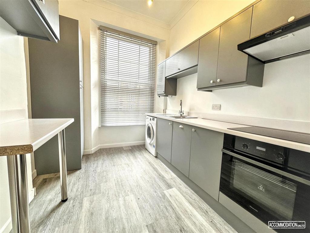 Bright modern kitchen with sleek grey cabinets,...
