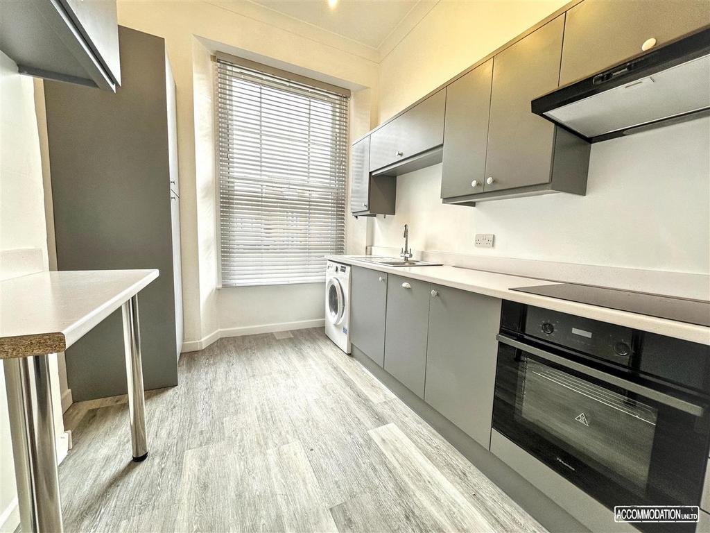 Bright, modern galley kitchen with sleek grey c...