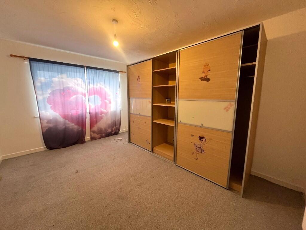 Bright, neutral bedroom with built-in wardrobe ...
