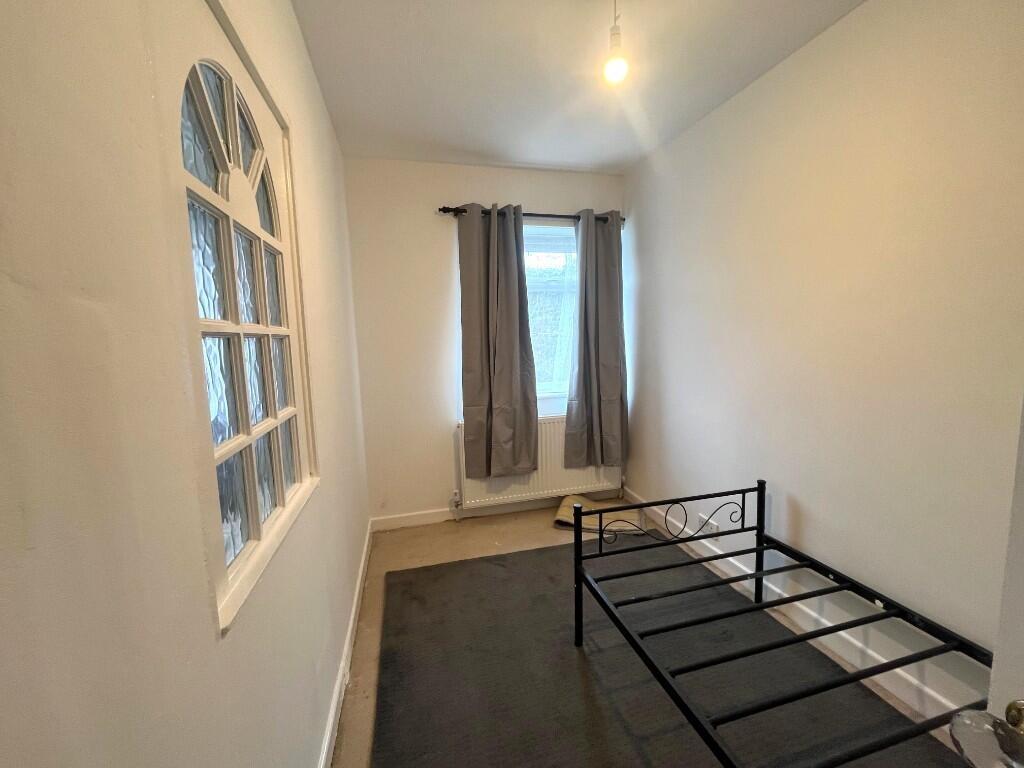 Neat, simply furnished single bedroom with a me...