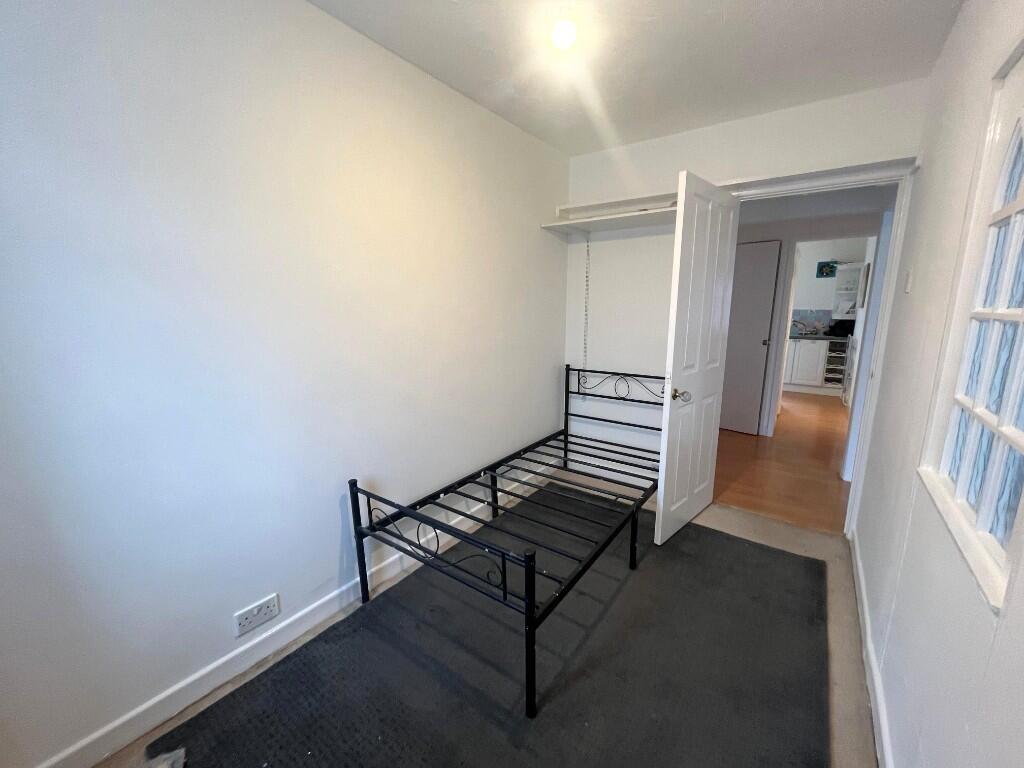 Neat, simply furnished single bedroom with a me...