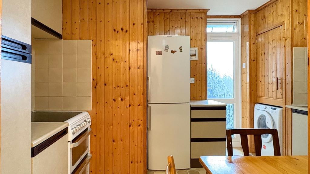Cosy kitchen with warm wood paneling, freestand...