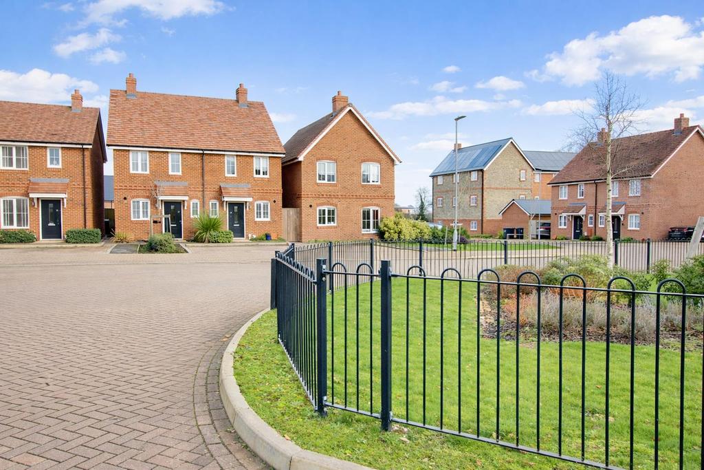 Sunny suburban street with brick houses.png