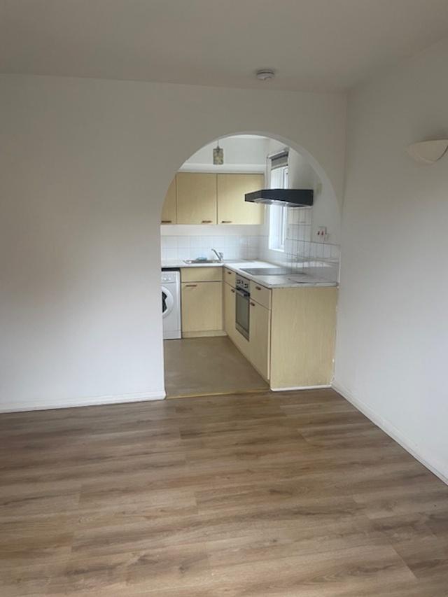 Open-plan living area with light wood flooring ...