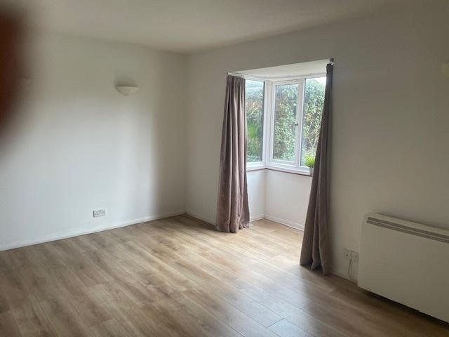 Bright, neutral living room with bay window and...