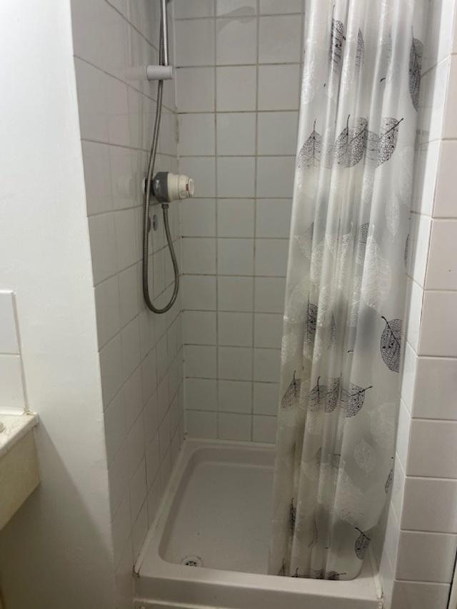 Tiled shower cubicle with an adjustable wall-mo...