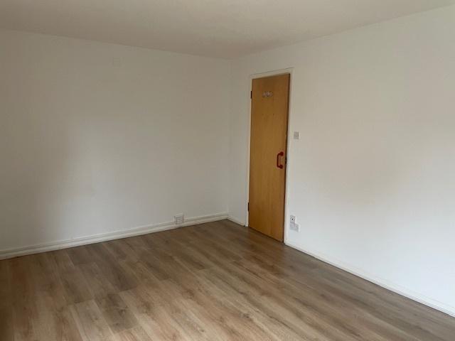 Bright, freshly painted bedroom with light wood...