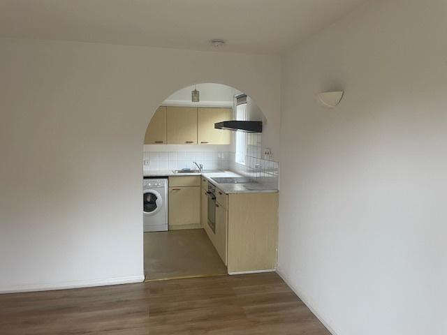 Bright, open-plan kitchen with an arched doorwa...