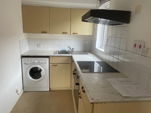 Neat fitted kitchen with marble-effect worktops...