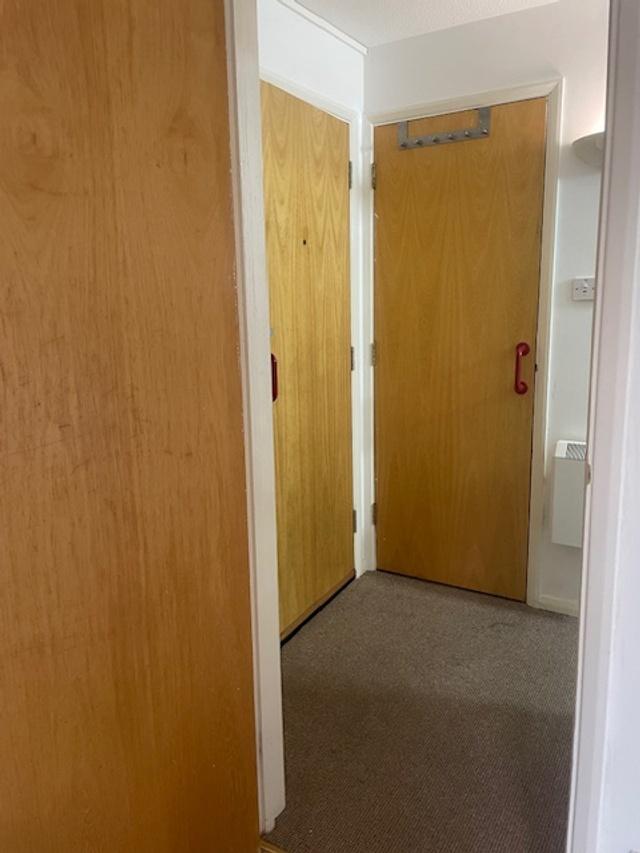Compact internal hallway with multiple wooden d...
