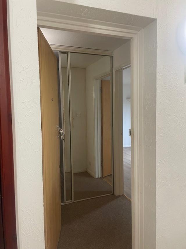 Neutral entry hallway with mirrored sliding war...