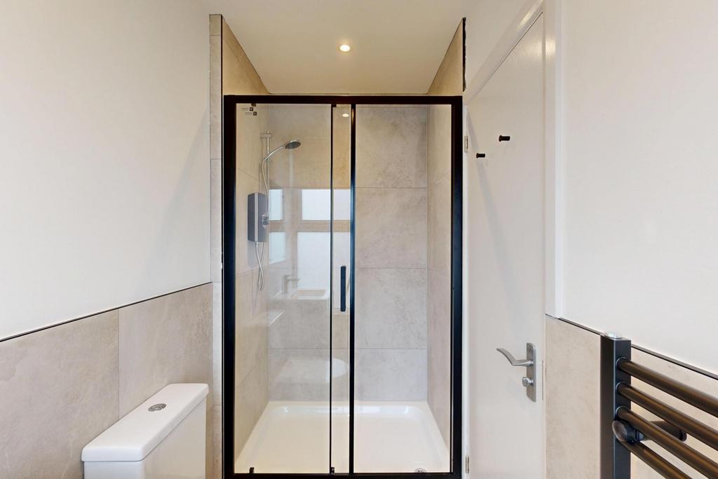 A clean, modern bathroom featuring a spacious s...