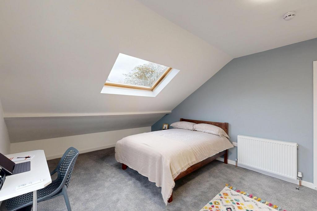 A bright and tidy bedroom featuring a comfortab...