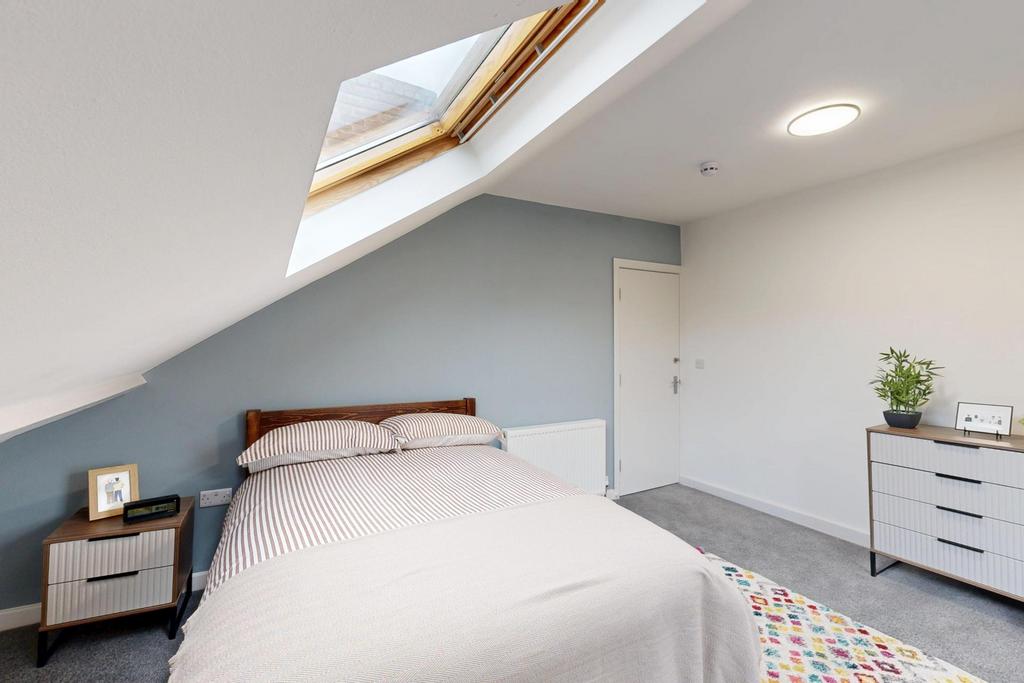 A well-lit, spacious bedroom with a comfortable...