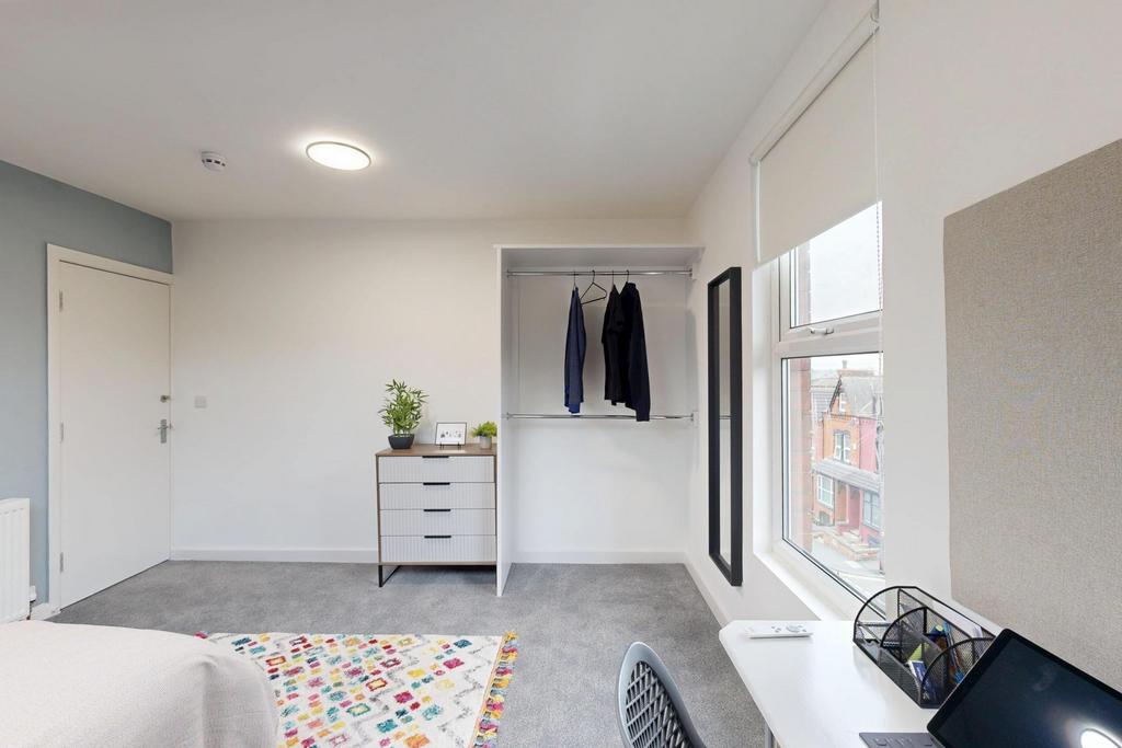 Bright and airy bedroom featuring a large windo...