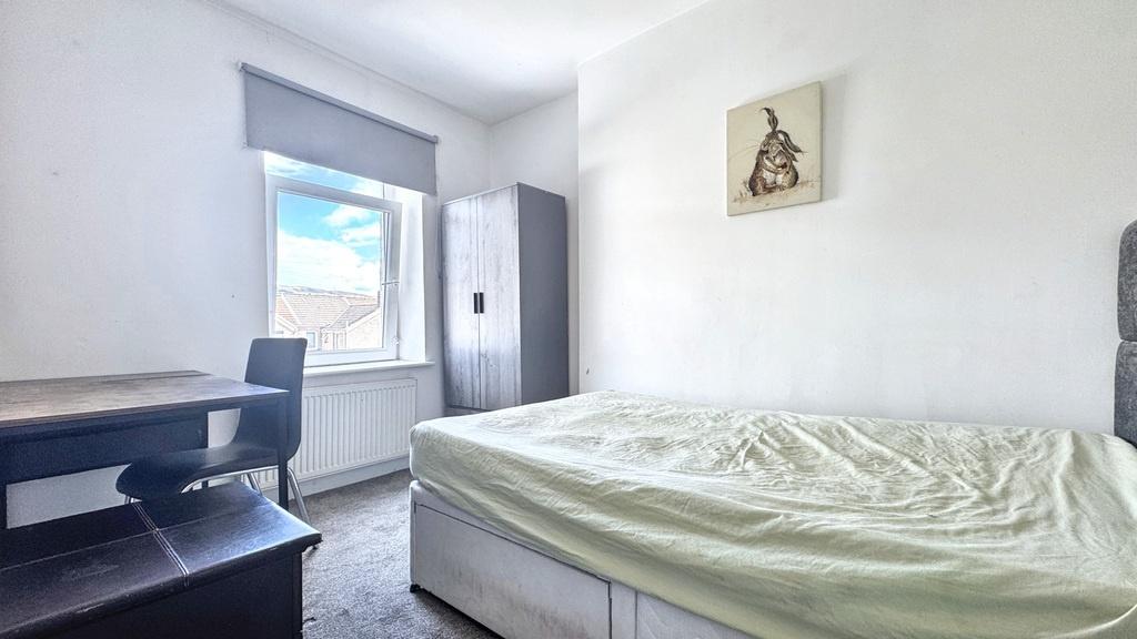 Bright, simply furnished bedroom with a large w...