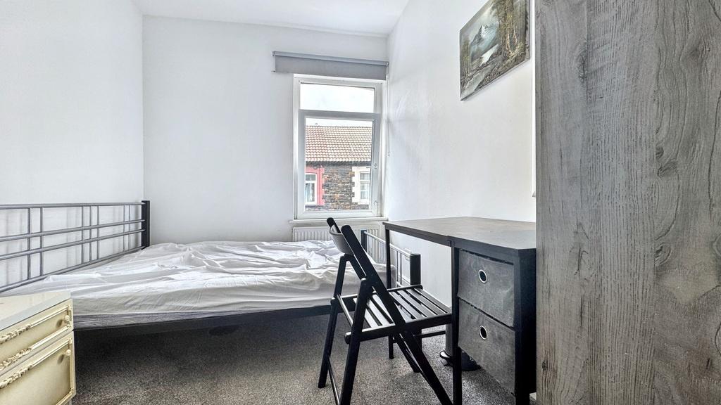 Bright, simply furnished bedroom with a metal b...
