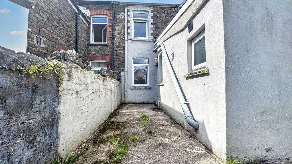 Narrow paved rear yard with direct access to th...