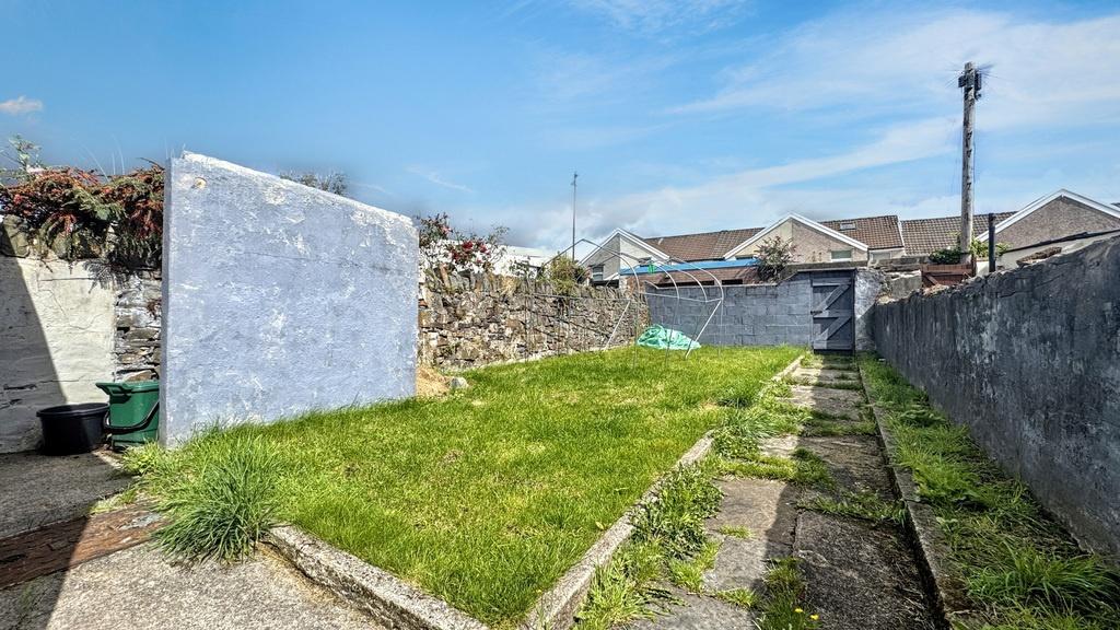 Sunny enclosed rear garden with a central lawn,...