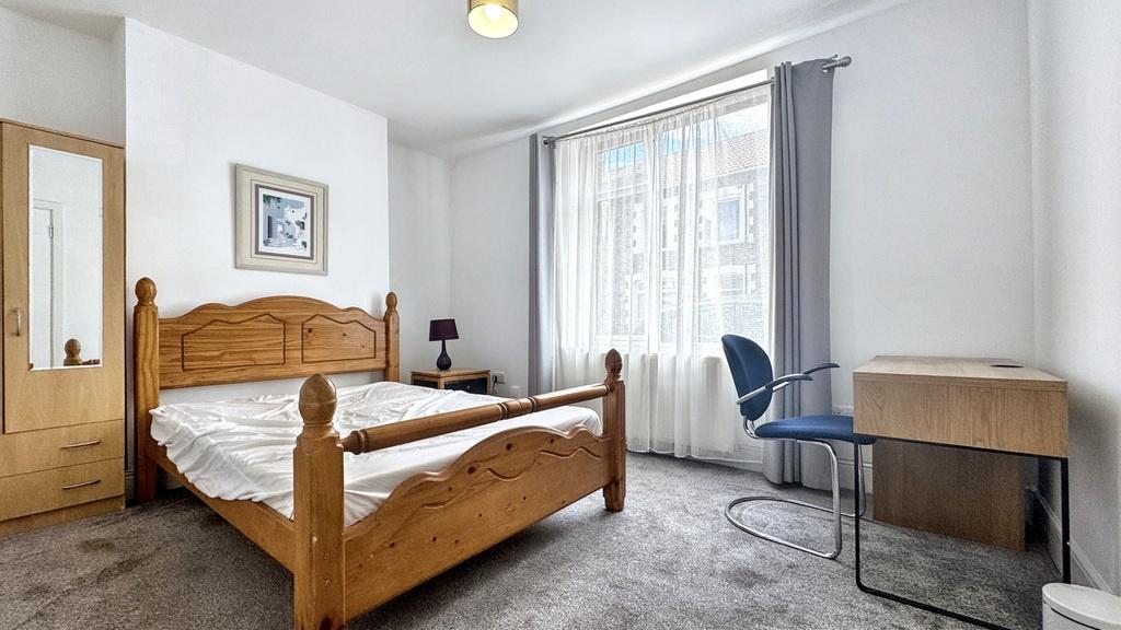 Bright, neatly presented bedroom with a solid w...