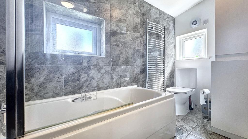 Modern bathroom with a white bath set against a...