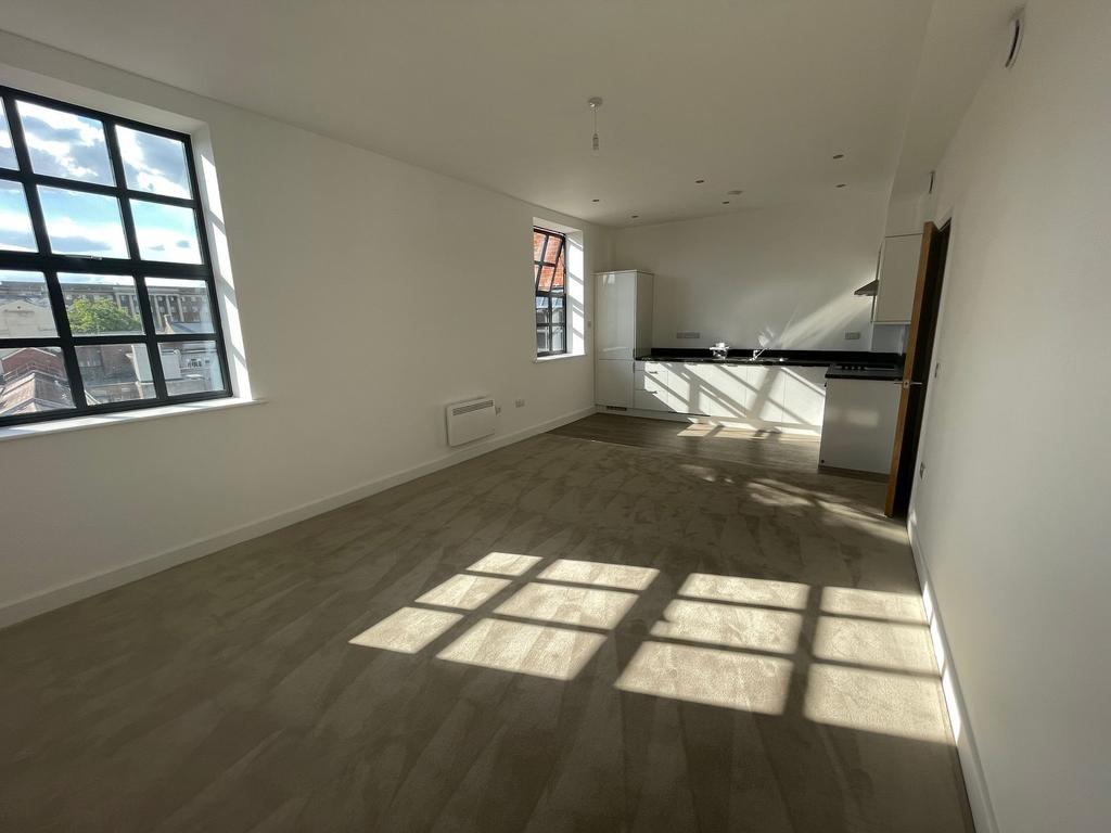 Bright, open-plan living area with large indust...
