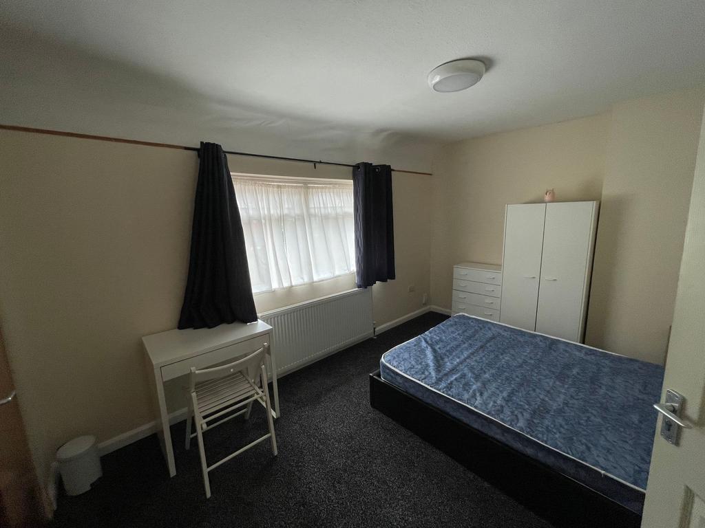 Bright, simply furnished bedroom with a double ...