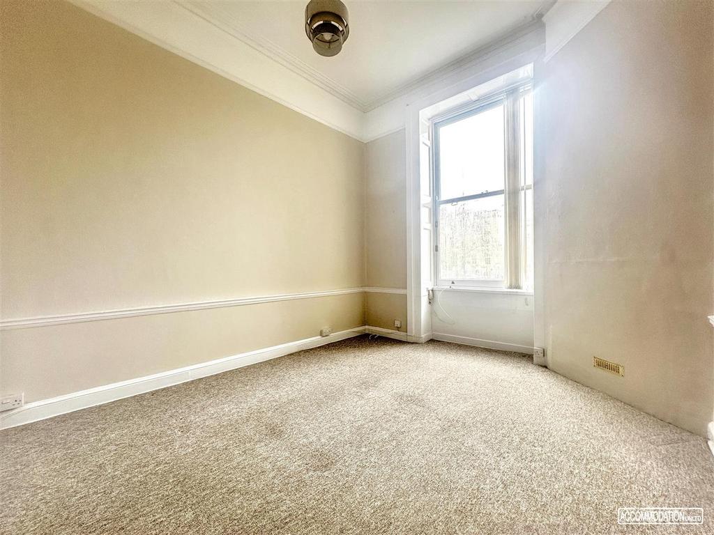Bright room with tall sash window and neutral d...