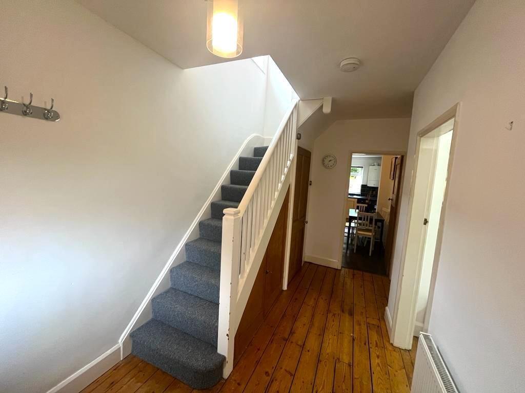 Bright, well-kept hallway with fitted under-sta...
