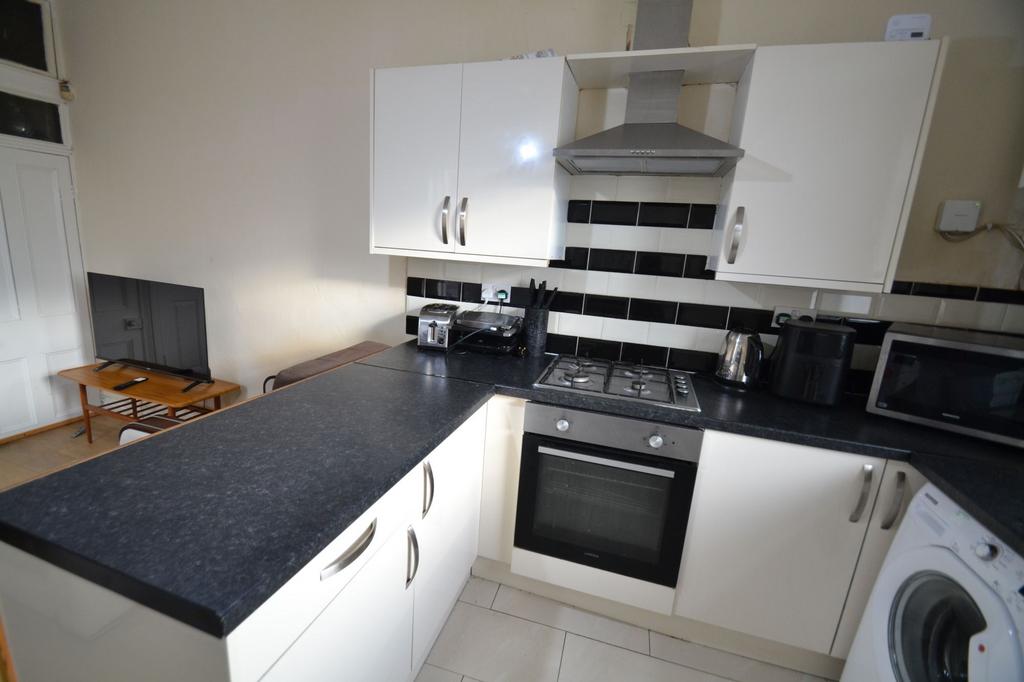 Modern fitted kitchen with dark worktops, black...