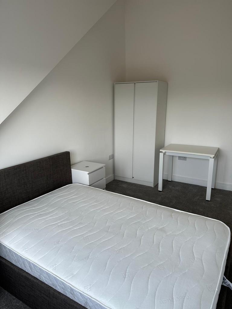 Bright, simply furnished double bedroom with a ...