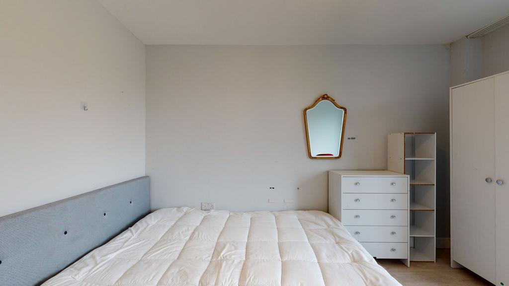 Bright, simply furnished bedroom with a comfort...