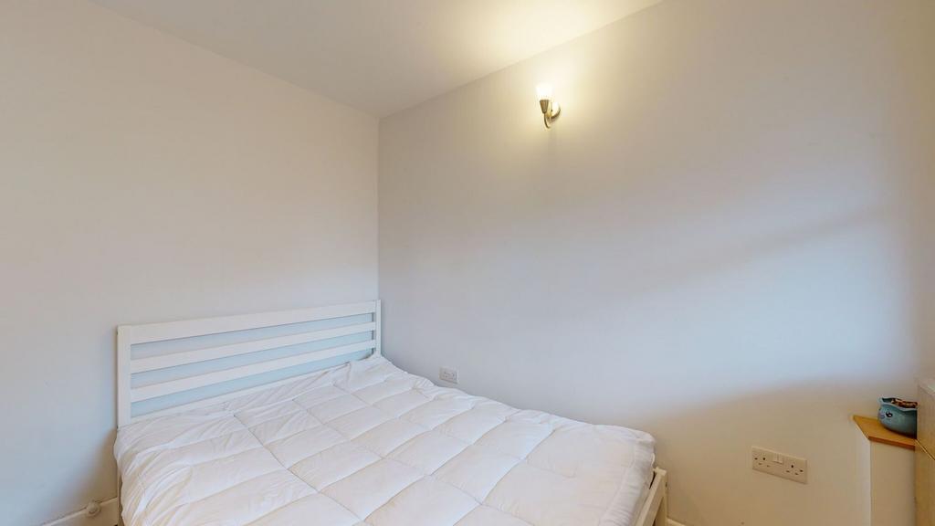 Bright, simply furnished bedroom featuring a wh...