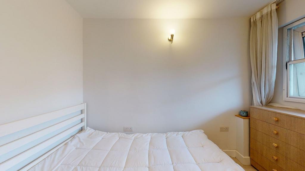 Bright, simply furnished bedroom with a white s...
