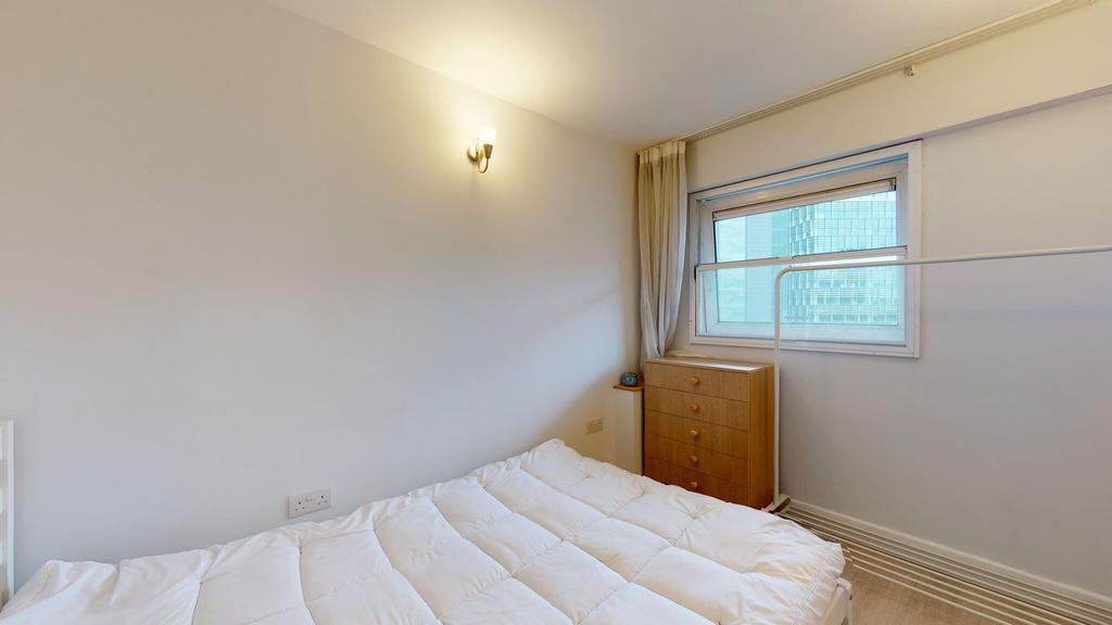 Bright, simply furnished bedroom with a comfy d...