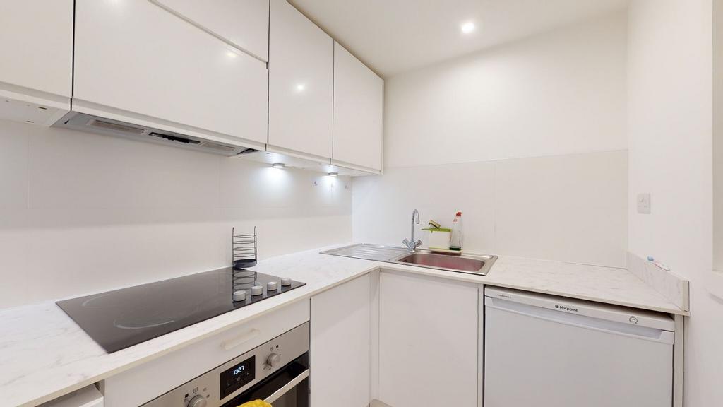 Bright modern white kitchenette with built-in h...