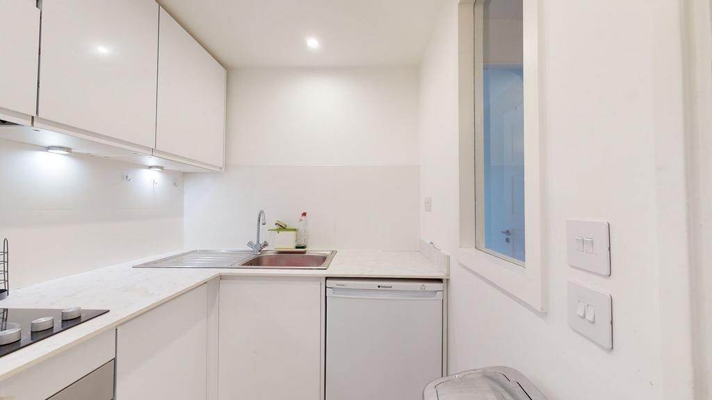 Bright, modern kitchenette with white cabinetry...