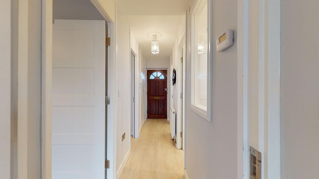 Bright, freshly painted hallway with light wood...