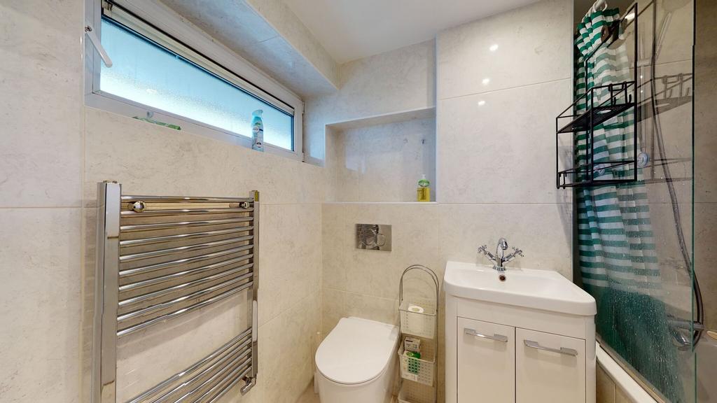 Bright, modern bathroom with tiled walls, a con...