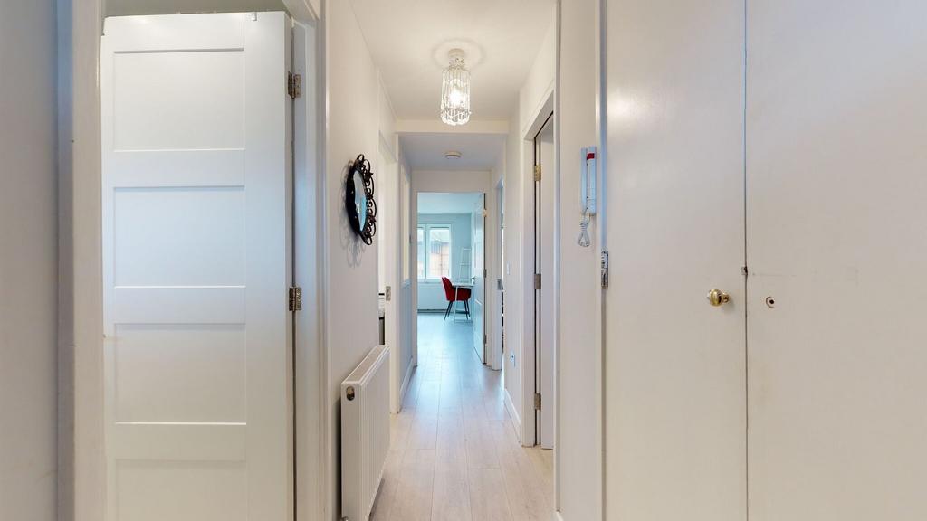 Bright, freshly painted hallway with light wood...