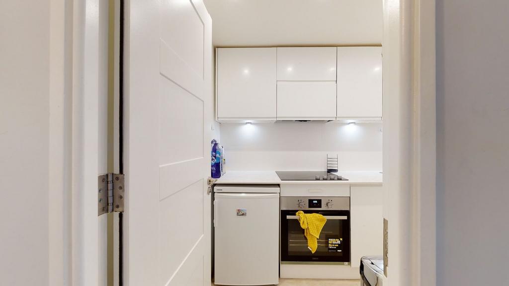 Bright, modern kitchenette with white gloss cab...