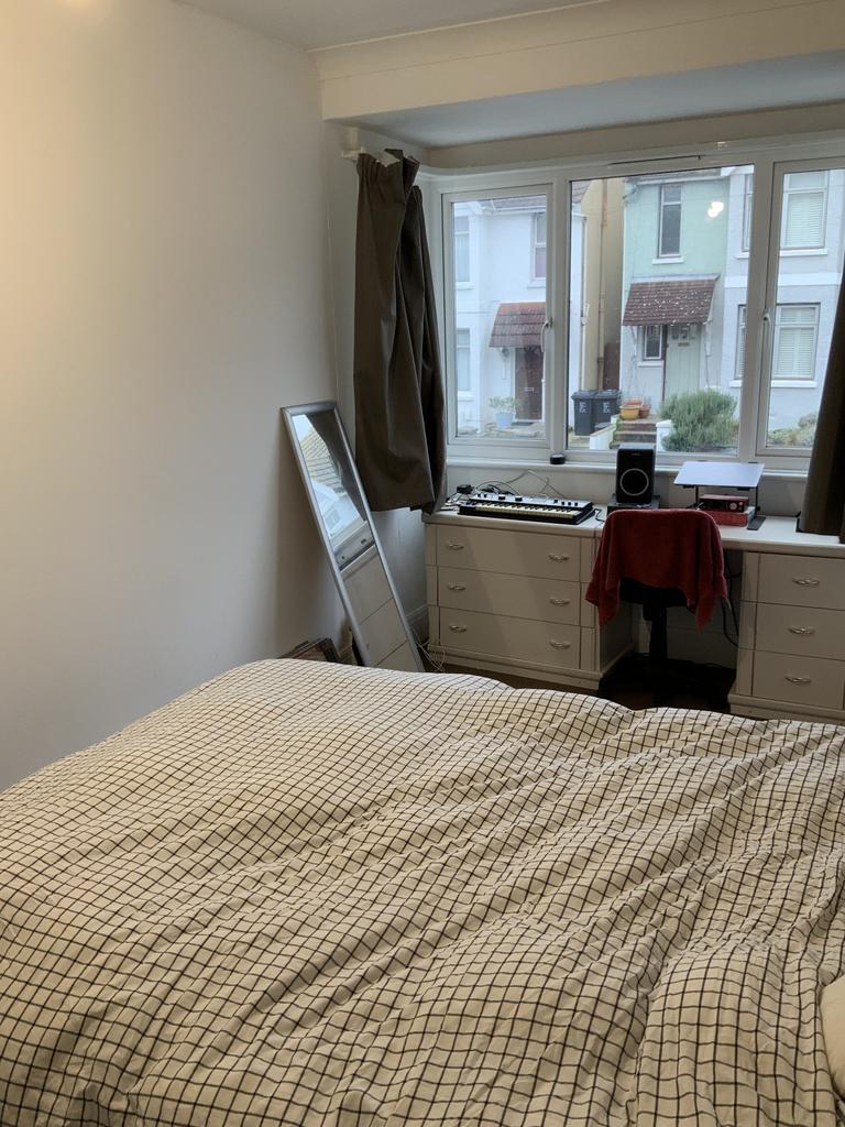 Bright, neatly arranged double bedroom with a c...