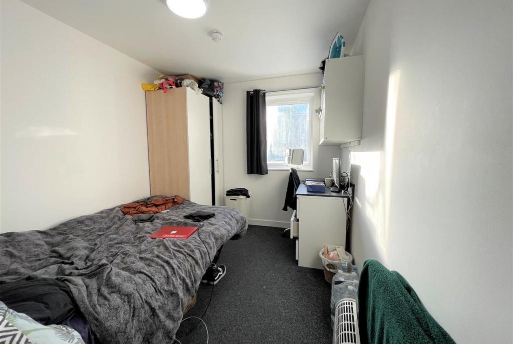 Compact furnished bedroom with a comfortable si...
