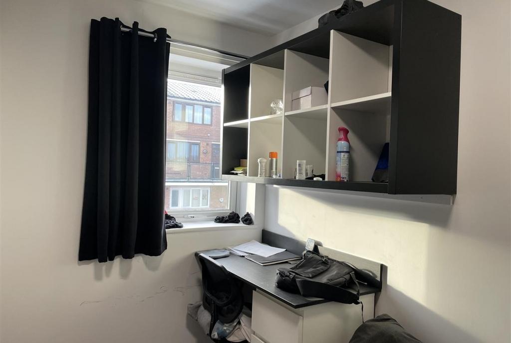 Compact bedroom with a window providing natural...